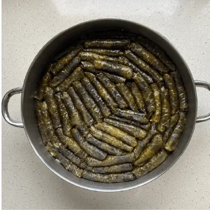 עלי גפן ממולאים מבושלים מסודרים בספירלה בסיר